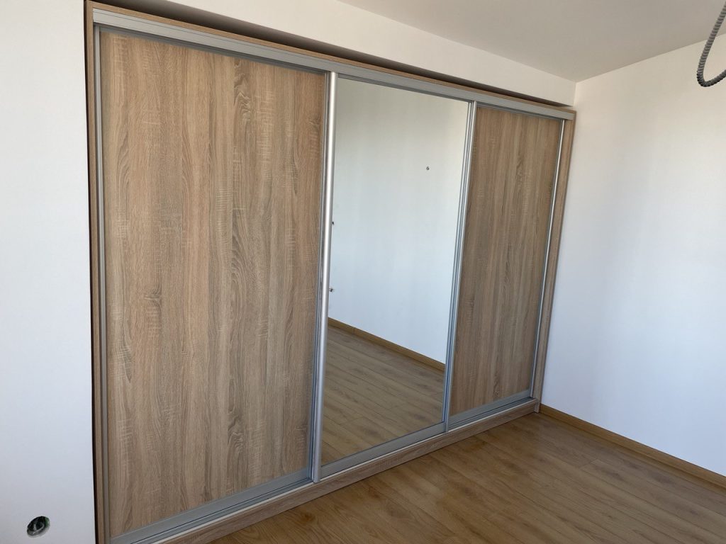шафа купе у ніші з дзеркалом та фасадами під дерево для невеликої квартири
