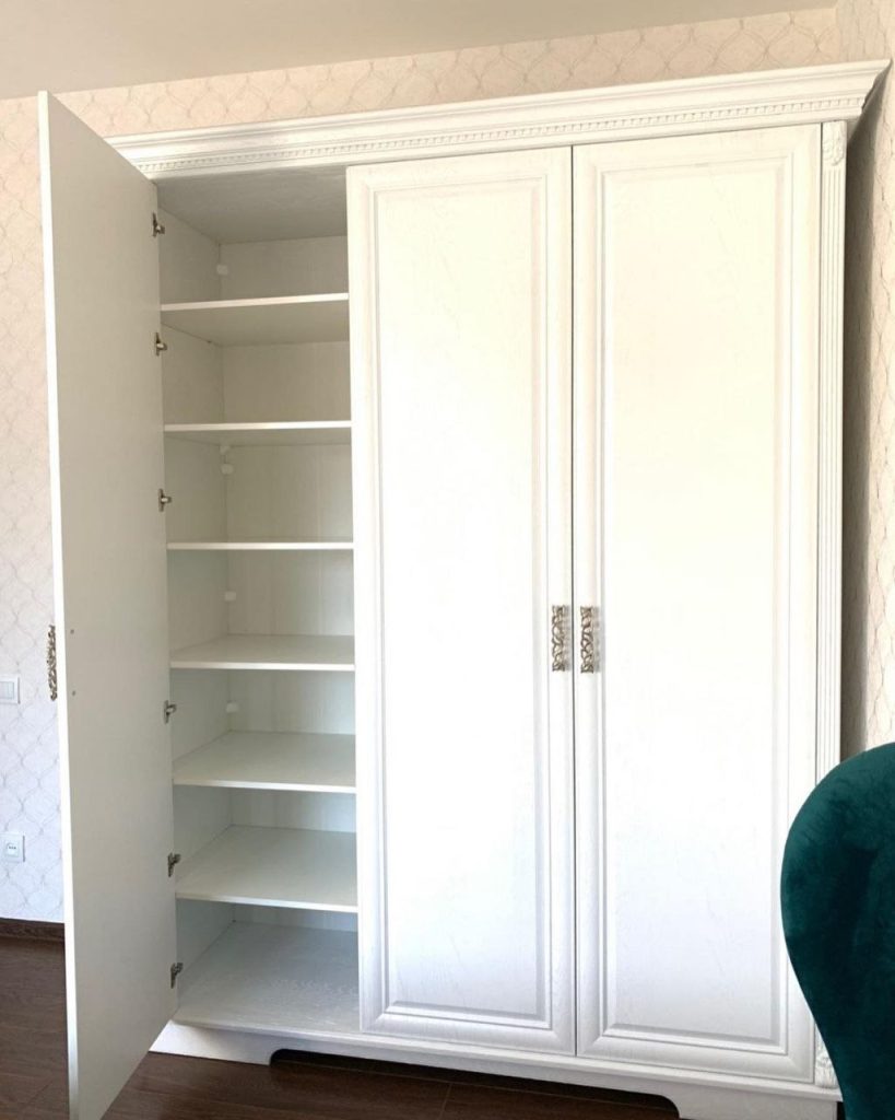 класична біла шафа з декоративними елементами та золотими ручками