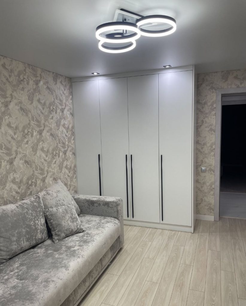 Розпашна шафа з чорними ручками та фурнітурою Blum